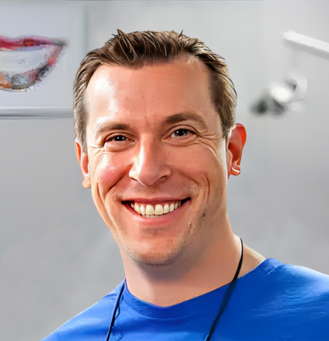 Smiling male dentist wearing blue scrubs in modern dental office setting.