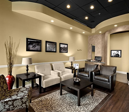 Modern dental office waiting room with beige walls, comfortable seating, and contemporary decor.