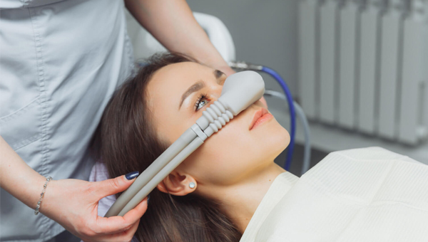 Dentist measuring patient's smile width during dental examination at Nelson Ridge Family Dental office.