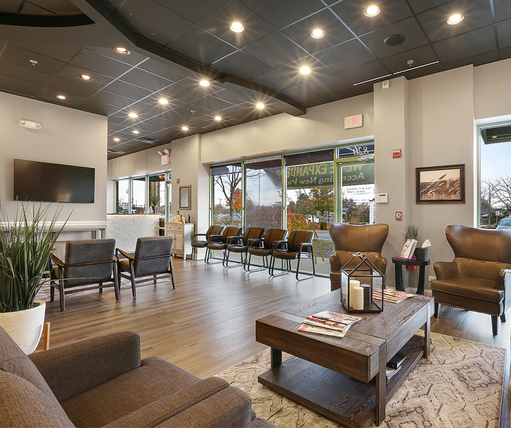Modern dental office lobby with comfortable seating, warm lighting, and welcoming contemporary interior design.